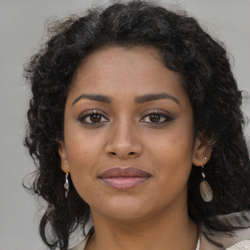 Joyful black young-adult female with long  brown hair and brown eyes