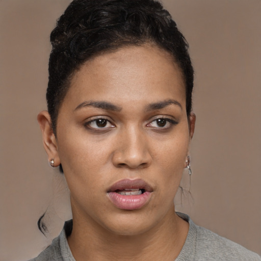 Joyful black young-adult female with short  black hair and brown eyes