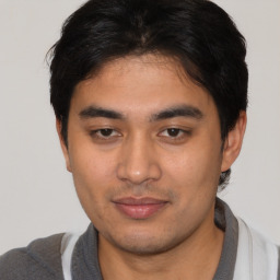 Joyful latino young-adult male with short  brown hair and brown eyes