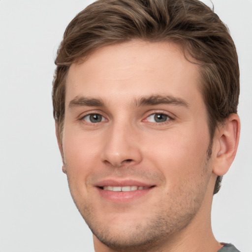 Joyful white young-adult male with short  brown hair and grey eyes