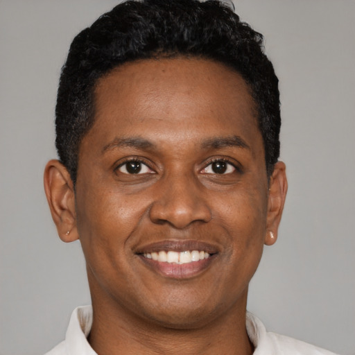 Joyful black young-adult male with short  brown hair and brown eyes