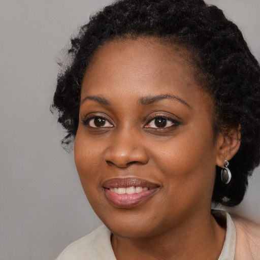 Joyful black young-adult female with medium  black hair and brown eyes