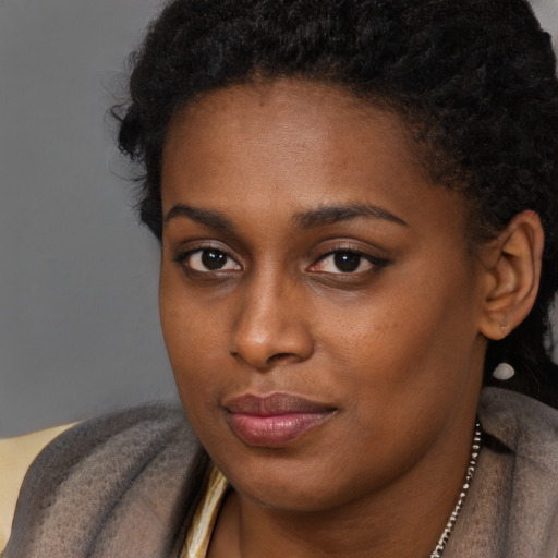 Joyful black young-adult female with short  brown hair and brown eyes
