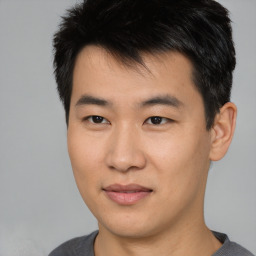 Joyful asian young-adult male with short  brown hair and brown eyes