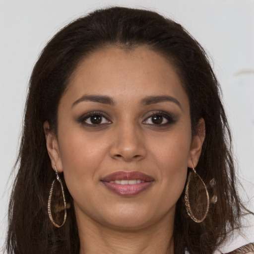 Joyful latino young-adult female with long  brown hair and brown eyes