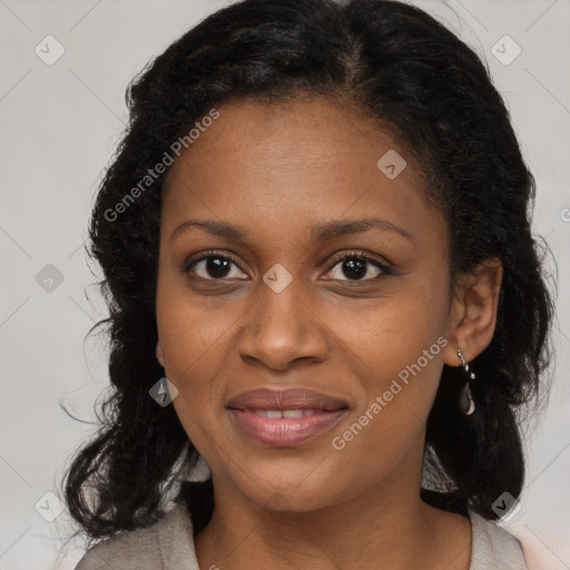 Joyful black young-adult female with long  black hair and brown eyes