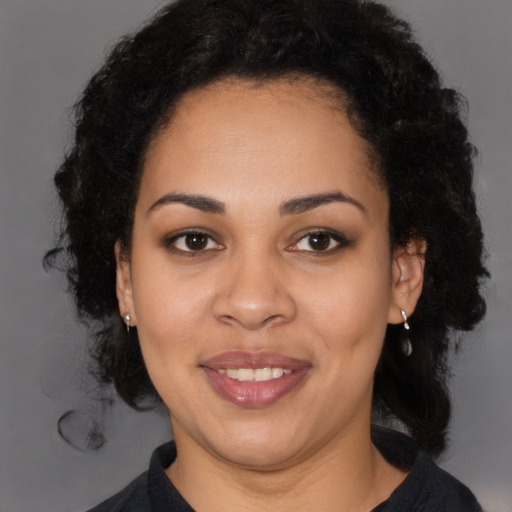 Joyful black young-adult female with long  brown hair and brown eyes