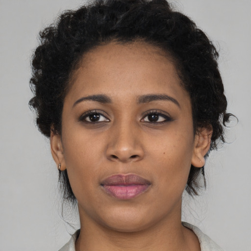 Joyful black young-adult female with short  black hair and brown eyes