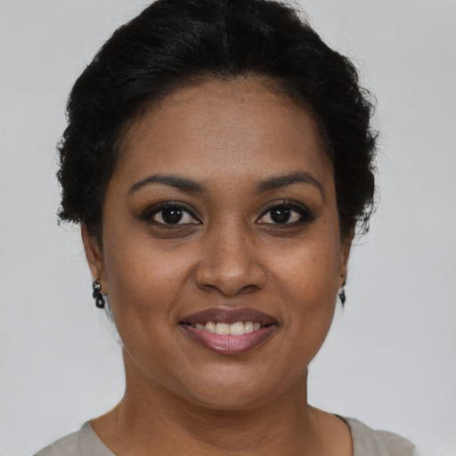 Joyful black young-adult female with short  brown hair and brown eyes