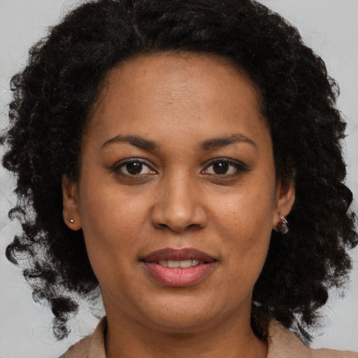 Joyful black adult female with medium  brown hair and brown eyes
