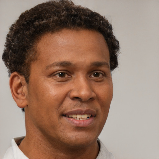 Joyful black young-adult male with short  brown hair and brown eyes