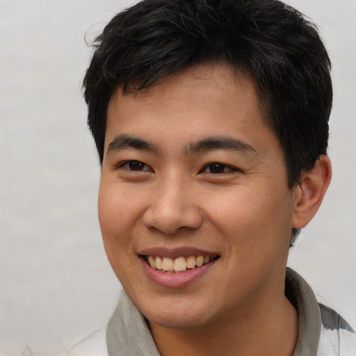 Joyful asian young-adult male with short  brown hair and brown eyes