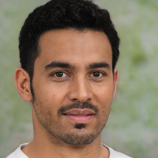 Joyful latino young-adult male with short  black hair and brown eyes