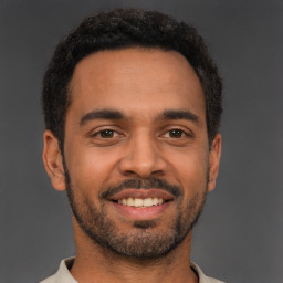 Joyful latino young-adult male with short  black hair and brown eyes