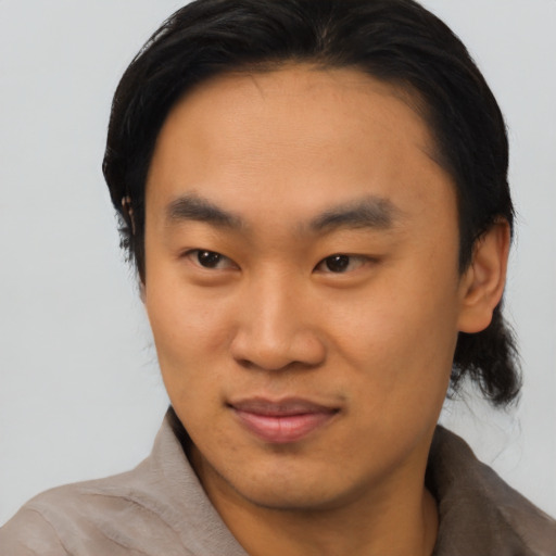 Joyful asian young-adult male with short  brown hair and brown eyes
