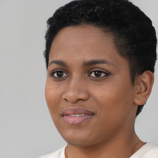 Joyful black young-adult female with short  black hair and brown eyes