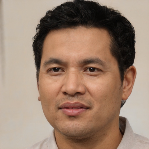 Joyful asian adult male with short  black hair and brown eyes