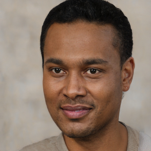 Joyful black young-adult male with short  black hair and brown eyes
