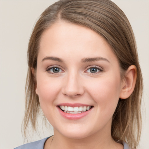 Joyful white young-adult female with medium  brown hair and grey eyes