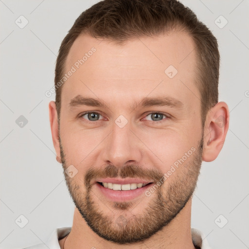 Joyful white young-adult male with short  brown hair and grey eyes