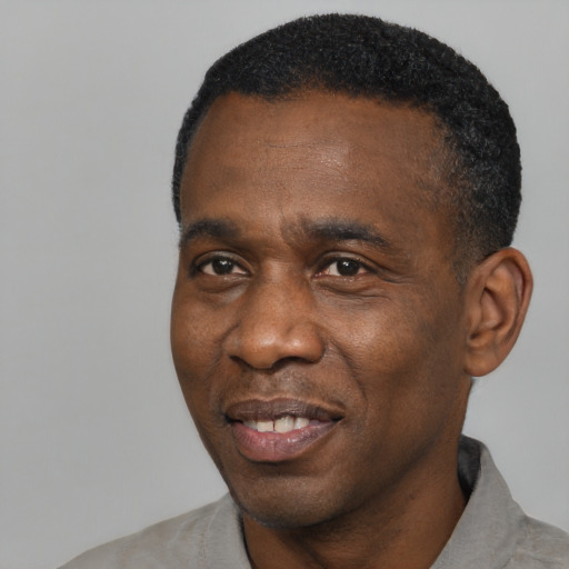 Joyful black adult male with short  black hair and brown eyes