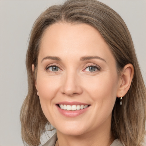 Joyful white young-adult female with medium  brown hair and grey eyes