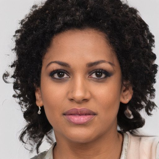Joyful black young-adult female with long  brown hair and brown eyes