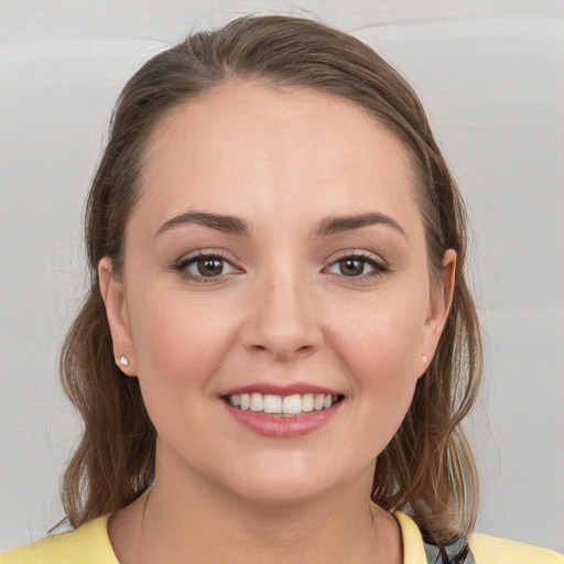 Joyful white young-adult female with medium  brown hair and grey eyes