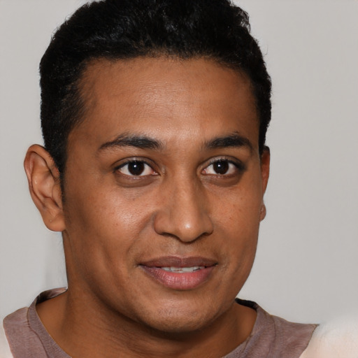 Joyful latino young-adult male with short  brown hair and brown eyes