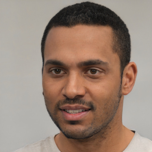 Joyful latino young-adult male with short  black hair and brown eyes