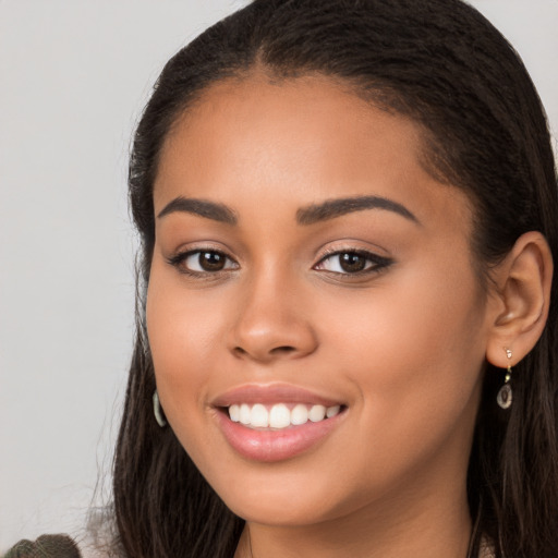 Joyful latino young-adult female with long  brown hair and brown eyes