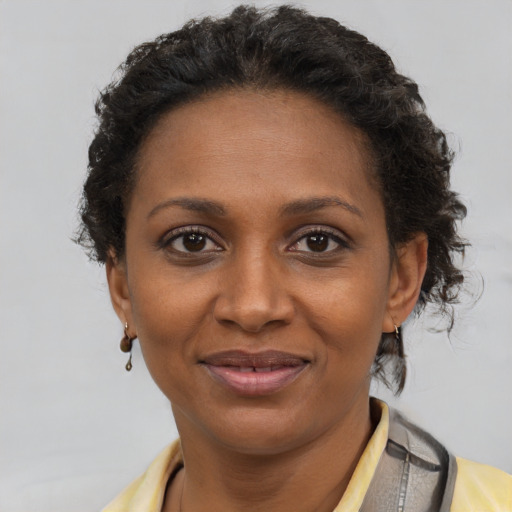 Joyful black adult female with short  brown hair and brown eyes