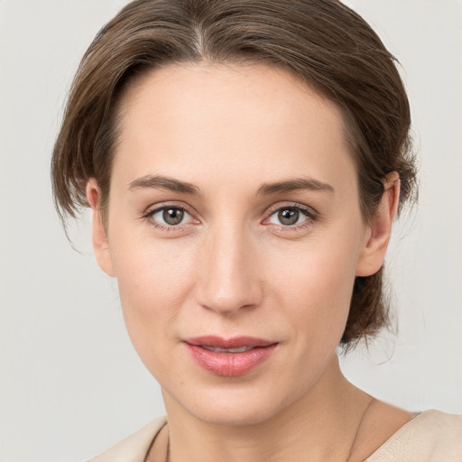 Joyful white young-adult female with medium  brown hair and grey eyes