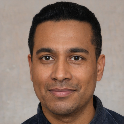 Joyful latino young-adult male with short  black hair and brown eyes