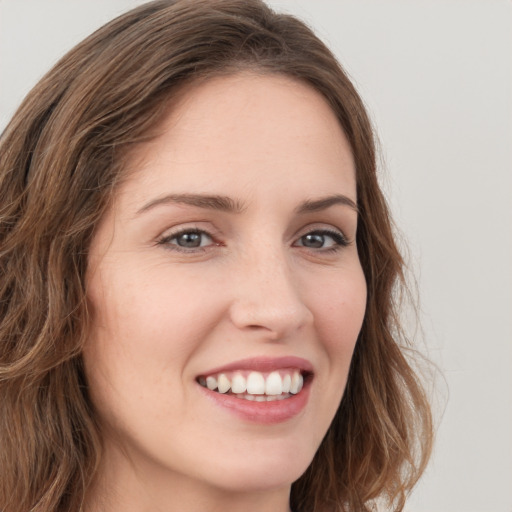 Joyful white young-adult female with long  brown hair and green eyes