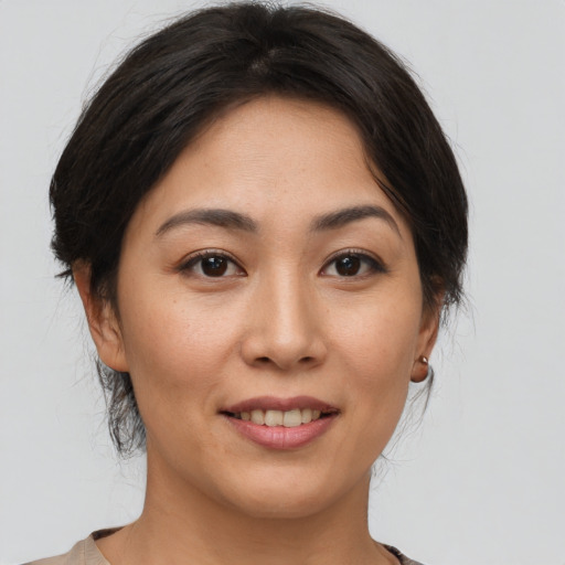 Joyful asian young-adult female with medium  brown hair and brown eyes