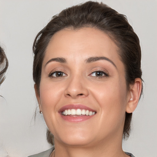 Joyful white young-adult female with medium  brown hair and brown eyes