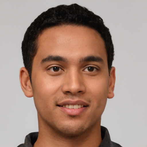 Joyful latino young-adult male with short  black hair and brown eyes