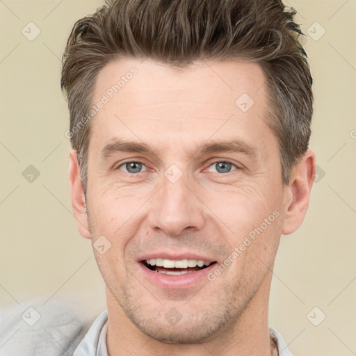 Joyful white adult male with short  brown hair and grey eyes