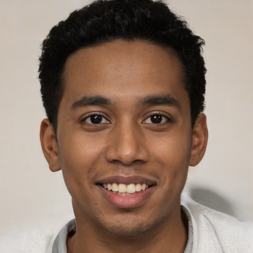 Joyful black young-adult male with short  black hair and brown eyes