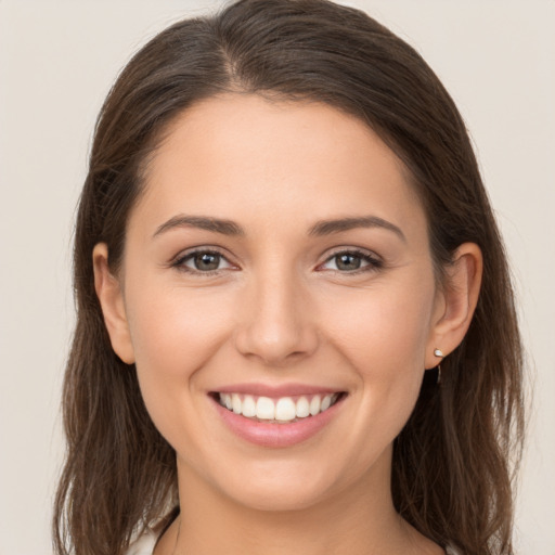 Joyful white young-adult female with long  brown hair and brown eyes