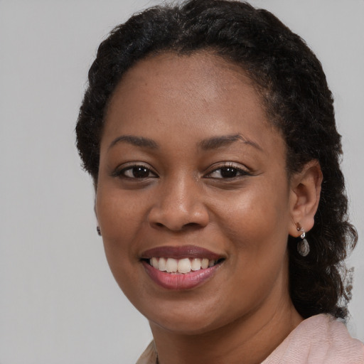 Joyful black young-adult female with medium  black hair and brown eyes