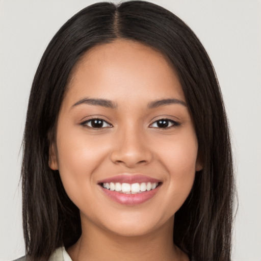 Joyful latino young-adult female with long  brown hair and brown eyes