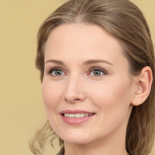 Joyful white young-adult female with long  brown hair and green eyes