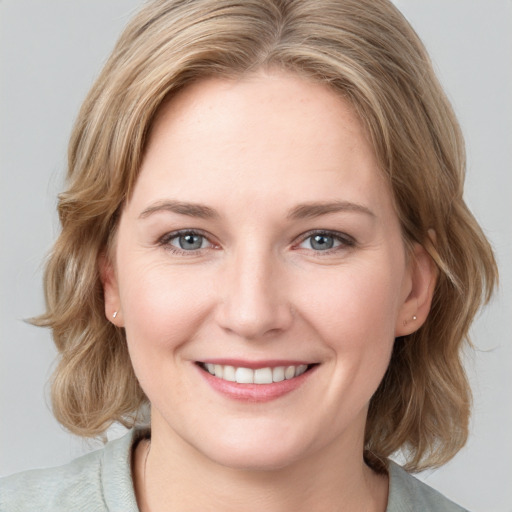 Joyful white young-adult female with medium  brown hair and blue eyes