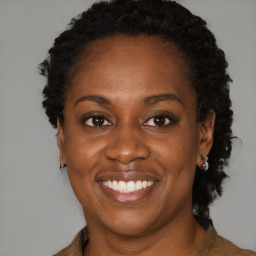 Joyful black adult female with medium  brown hair and brown eyes