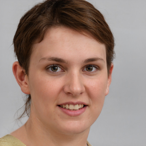 Joyful white young-adult female with short  brown hair and grey eyes