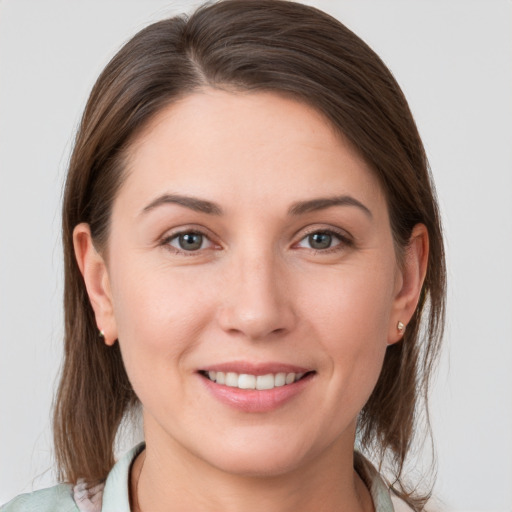 Joyful white young-adult female with medium  brown hair and grey eyes