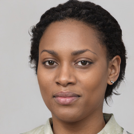Joyful black young-adult female with long  black hair and brown eyes