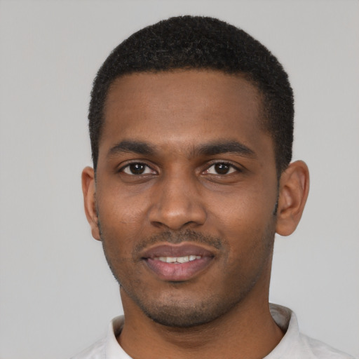 Joyful black young-adult male with short  black hair and brown eyes